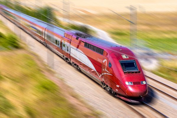 A Thalys high speed train at full speed in the countryside with motion blur.