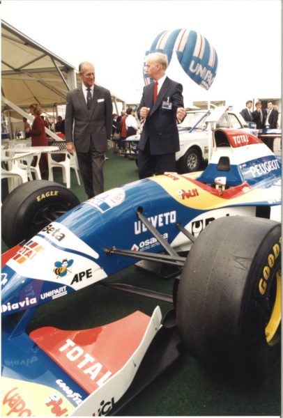 John Neill shows Prince Philip a Formula 1 car at Unipart in June 1995